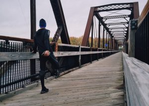 biegacz rozciągający się na moście